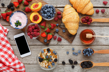 Morning meals and smartphone on rustic wooden table