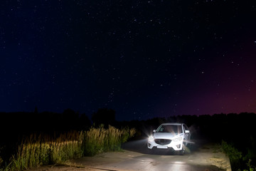 car with headlights against the star sky