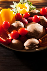 Different type of fresh organic vegetables on burned wooden background in studio photo