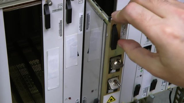 IT engineer insert optical patch cord in card on datacenter.