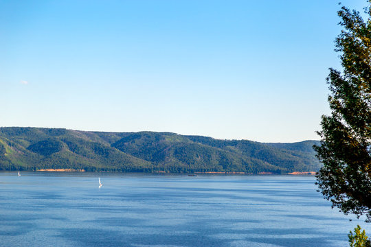 boats with white sails float on the background of mountains