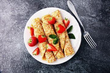 Crepes with jam, berries and sugar powder. Homemade pancakes, delicious breakfast.