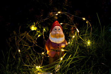 garden gnome and lights in the evening in the grass