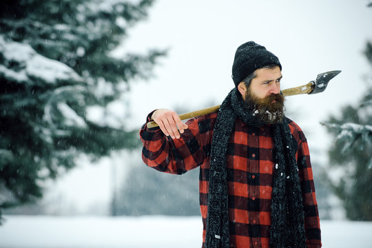 christmas man with beard hold axe in winter forest