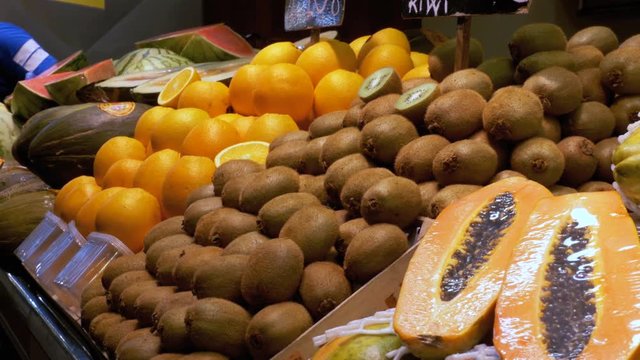 Counter with Fruits at a Market in La Boqueria. Barcelona. Spain. Peach, grapes, kiwi, mango and other exotic fruits on display on the showcase at Mercat de Sant Josep.