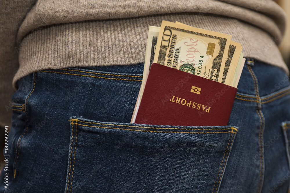 Wall mural Passport in the back jeans pocket with American dollars.