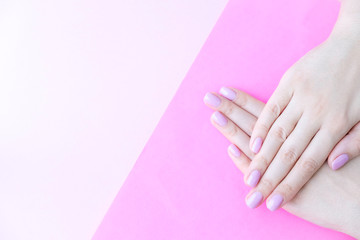 Close up pink nails for girls. Stylish trendy female manicured fingernails. Beautiful young woman's hands on pink and blue background. Top view, flat lay. copy space for text