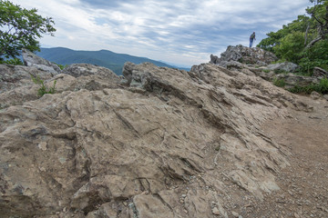 Fototapeta premium Man hiking with stick on rock bar cliff .