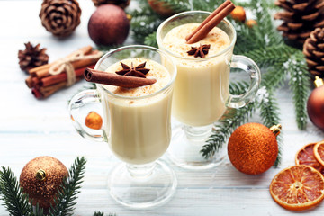 Eggnog in glasses with cinamon and star anise on wooden table