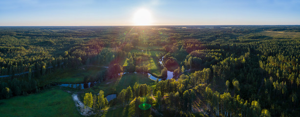 Fototapeta premium Aerial View. Flying over the beautiful summer rivers at sunset.
