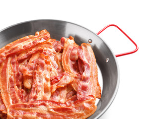 Frying pan with cooked bacon rashers on white background