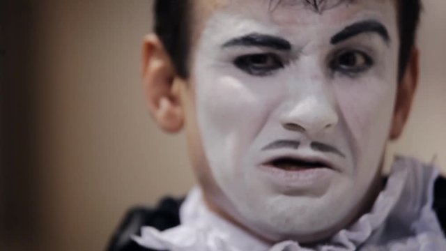 mime with a white make-up on her face shows different emotions