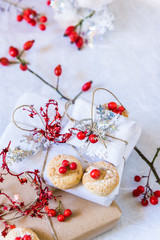pacchetti di natale, biscotti e bacche rosse su sfondo bianco