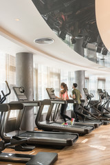 Paar joggt auf dem Laufband im Fitnessstudio bei Cardio Training
