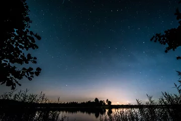 Foto op Canvas Stars over the lake at summer night on dark sky. Starfall. Milky way. © nikwaller