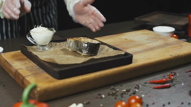 Fish Cooked and Served with sauce and salt on a wooden board