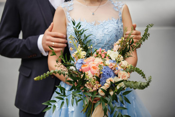 Wedding couple. Groom and bride with wedding bouquet of fresh flowers
