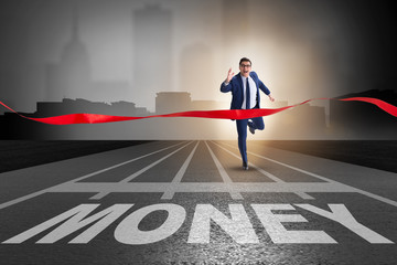 Businessman running towards money on track