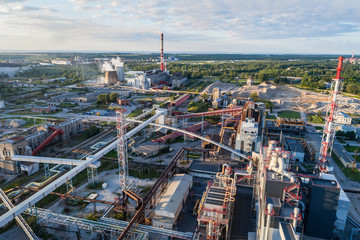 Obraz premium Widok z lotu ptaka Rafineria ropy naftowej na tle gór i nieba o zachodzie słońca. Fotografia lotnicza. Miasto Kohtla-Järve, Estonia, Ida-Virumaa.