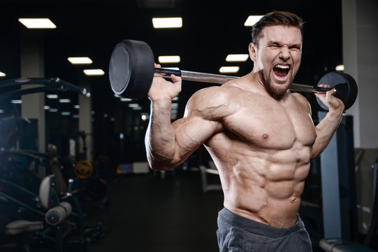 Brutal strong bodybuilder athletic men pumping up muscles with dumbbells.