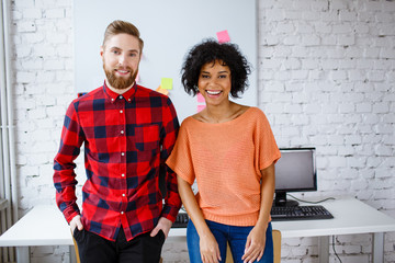 Two university students standing together in classroom