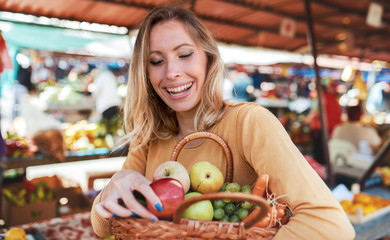 Young woman buying at street market. Lifestyle, consumerism, shopping