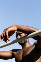 Athletic black man posing in a city park
