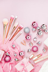 Flat Lay Holiday Background with Christmas ball, gift, ribbon and decorations in pastel pink colour. Flat lay, top view