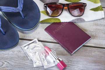 Fototapeta na wymiar Vacation concept. Summer beach background with sunglasses, slippers, passport, condoms, copy space
