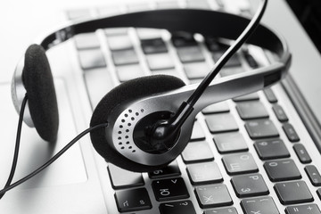 call center support concept. headset on keyboard computer laptop