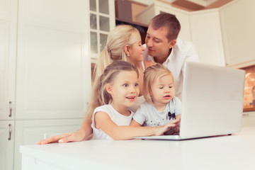 Young family of three using laptop while lying on carpet at home
