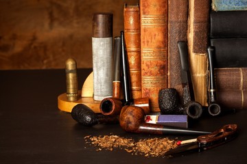 Obraz premium Tobacco and old books. Reading a detective novel.
