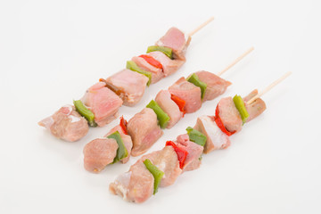 skewers of raw meat and vegetables