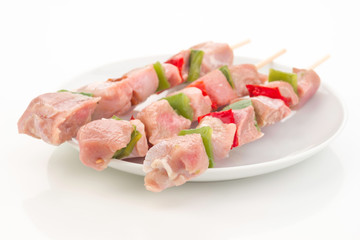 skewers of raw meat and vegetables