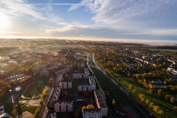 Fototapeta premium Aerial view of beautiful sunrise over the city. City in fog, misty landscape.