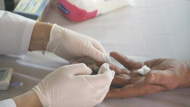 Closeup of nurse hands doing finger blood testing