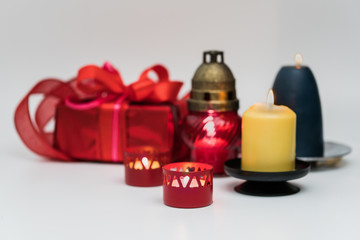 Red gift box with ribbon, surrounded by candles.