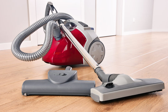 Canister vacuum cleaner for home use on the floor panels