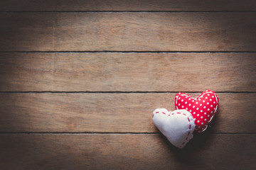 Two heart shape toys on wooden background