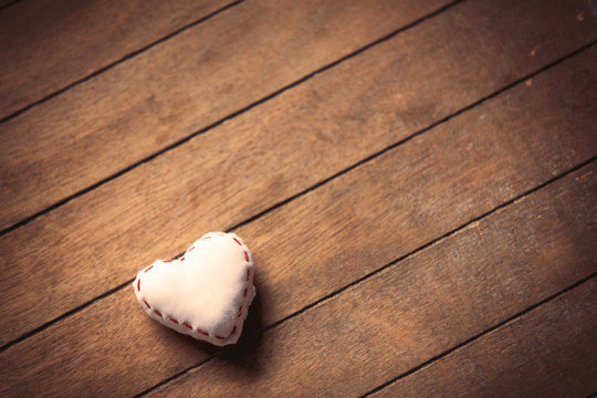 Heart shape toy on wooden background