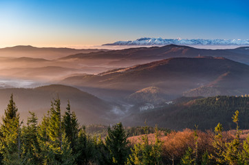 Naklejka premium panorama over misty Gorce to snowy Tatra mountains in the morning, Poland landscape