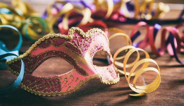 Carnival party. Mask and serpentines on wooden background
