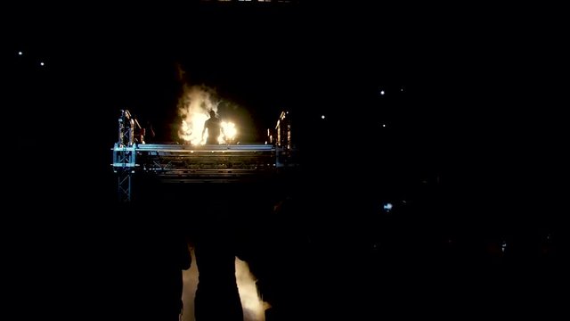 Fighter in dark comes to ring and smoke. Background fans, MMA. Fighter presentation before fight. Shadow of fighter and smoke with lights
