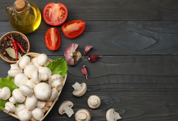 mushrooms with tomatoes, parsley, oil, garlic, chili pepper, peppercorns on dark wooden background. top view