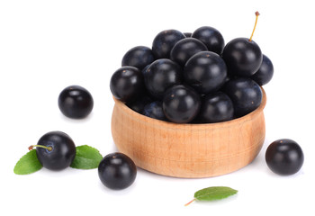 blackthorn berries in wooden bowl with green leaf isolated on white background