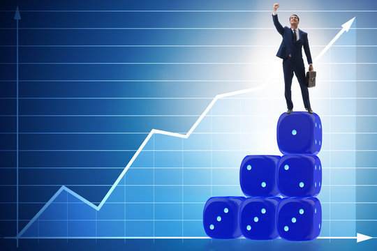 Businessman balancing on top of dice stack in uncertainty concep