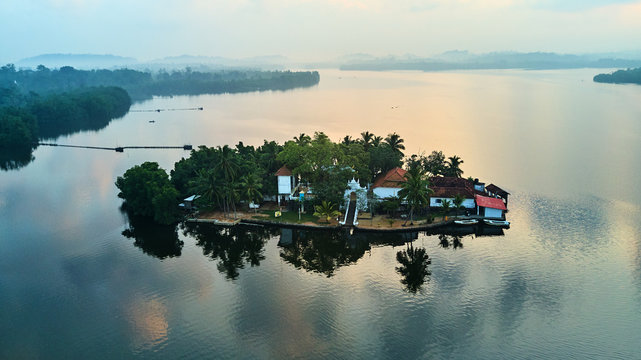 aerial shot of island with buildings in tropical lake