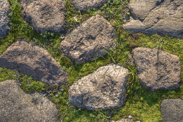 Fragment of the old road paved granite stones