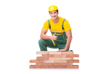 The handsome construction worker building brick wall