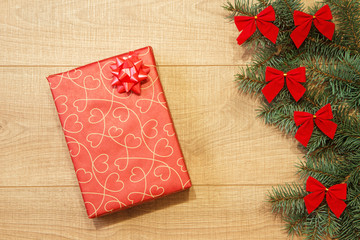 New Year / Christmas gift in package, tree with red bows on the wooden background template